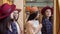 Two young lovely women trying on hats, while shopping together