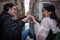 Two young lovers sitting in front of the canal draw a heart with their fingers