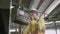 Two young maintenance man in uniform checking on machine and calling with radio phone at industrial factory.