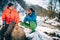 Two young male tourists talk while drinking coffee near a river in the mountains.