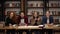 Two young male and two female european students sitting at the table with books and laptop in the library and cheerfully