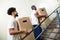 Two Young Male Worker Holding Cardboard Boxes