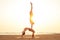 Two young man and beautiful woman on beach doing fitness yoga exercise together. Acroyoga element for strength and