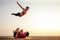 Two young man and beautiful woman on beach doing fitness yoga exercise together. Acroyoga element for strength and