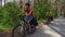 Two young men with backpacks ride bicycles along the road.