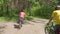 Two young men with backpacks ride bicycles along the road.