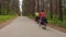 Two young men with backpacks ride bicycles along the road.