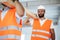 Two young men builders carrying wood planks on construction site, close up