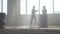 Two young men in casual clothes in the dark dusty abandoned building practicing dancing in front of window.. A teenager