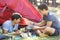 Two Young Men Cooking On Camping Stove Outside Tent