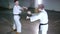 Two young men in kimono training their skills on a underground parking lot. Sword fight