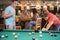 Two young men playing pool at a bar