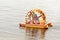 two young men sail on an inflatable catamaran with a large wheel propeller along the Volga River