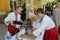 The two young men waiter in national Ukrainian costumes filled the fountain with hot chocolate for the national dishes.