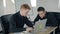 Two young men working using laptop in workplace in modern office.