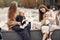 Two young mothers sitting in a autumn park with carriages