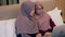 Two young muslim woman watch video on laptop in the bedroom