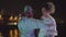 Two young people dancing at seafront at night