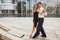 Two young people dancing tango outside on city embankment