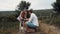 Two young people in love walk in the field with their dog. They walk and admire the beauty of nature.