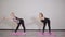 Two young pregnant women do fitness gymnastics in a sports club