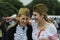 Two young pretty women in Soviet Red Army soldier side caps laughing and communicating, celebrating the Victory Day