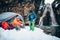 Two young professional male tourists are preparing to camp in the mountains near the river in winter.