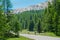 Two young road cyclists ride along the scenic freeway in the sunny French Alps.