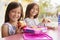 Two young schoolgirls at lunch looking to camera