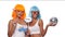 Two young smiling Asian women in bright color wigs and sunglasses posing with photo booth props and small disco ball over white