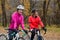 Two Young Smiling Female Cyclists with Road Bicycles Resting and in Park in Cold Autumn Day. Healthy Lifestyle.