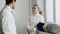 Two young smiling fencers man and woman sharing experience during break of fencing match indoors