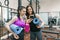 Two young smiling fitness women talking with sport mats in the gym. Training, teamwork, healthy lifestyle concept