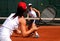 Two young sporty female tennis players having a game in the sun.