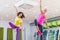 Two young sporty women exercising in fitness studio, dancing, doing cardio, working on balance and coordination.