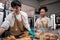 Two young startup partners taking orders of pastry and bakery food shop