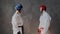 Two young strong teens in protective helmet and fight box gloves warm up muscles, take a fighting stance and looking