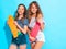 Two young stylish smiling beautiful girls with colorful penny skateboards