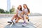 Two Young Woman sitting on Skateboard Happy Smiling. Playful Friends Enjoy Sunny day. Outdoor Urban. Beautiful Model