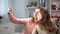 Two young woman taking selfie by smartphone, female friends leisure, technology