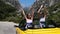 Two young woman in yellow car enjoying vacation