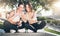 Two young women athletes in sportswear are sitting in park, relax after sports training, use smartphone.