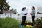 Two young women in the background of a garden with gloves and tools with a field of beds