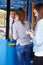 Two Young Women Boarding Bus And Buying Ticket