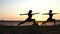 Two Young Women do Warrior 2 Exercises at a Splendid Sunset in Slo-Mo