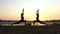 Two Young Women do Yoga Warrior Exercise at a Splendid Sunset in Slo-Mo