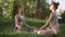 Two young women doing breathing practice and doing yoga outdoor