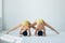 Two young women doing yoga asana wide legged forward bend