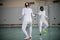 Two young women fencers having a training - standing in attack pose