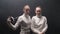 Two young women fencers standing in the dark studio - posing for the camera